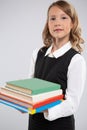 An expressive portrait of a smiling beautiful young schoolgirl with school textbooks. Royalty Free Stock Photo