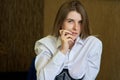 Expressive portrait of a young woman in a karset and a white shirt. European girl close up