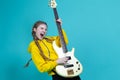 Expressive Positive Caucasian Teenager Guitar Player With Yellow Bass Guitar Posing In Fashionable Yellow Hoody Jacket With