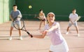 Expressive resolved fit girl playing frontenis ball friendly match on court