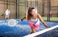 Expressive resolved girl playing paddle ball on closed court