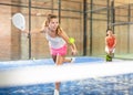 Expressive resolved girl playing paddle ball on closed court