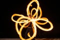 Expressive style couple of fire dancers spin burning pois creating sparkling patterns on dark outdoors, spinners