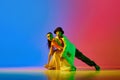 Expressive, talented, artistic young man and woman, hip hop dancers in motion, performing against blue red background in