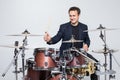 Expressive young drummer playing at the drums with drum stick isolated on white background Royalty Free Stock Photo