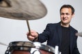 Expressive young drummer playing at the drums with drum stick isolated on white background Royalty Free Stock Photo