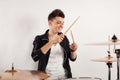 Expressive young drummer playing at the drums with drum stick Royalty Free Stock Photo