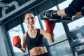 expressive young female boxer exercising with trainer