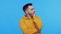 Expressive young man over vibrant background. Studio portrait of borred person.