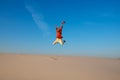Expressive young woman jumps on the desert Royalty Free Stock Photo