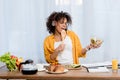 expressive young woman listening music and preparing salad