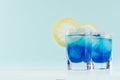 Exquisite blue cocktails for celebration in beach style with blue curacao, ice cube, sugar rim, lemon slice in mint color bar. Royalty Free Stock Photo