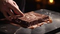 A close-up of a chocolatier's hand gently spreading Couverture Chocolate onto a marble slab