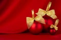 Exquisite glossy balls with golden bow on elegant dark silk backdrop with smooth waves, copy space, closeup. Rich christmas.