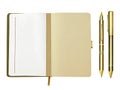 An exquisite golden ballpoint pen, a ripped-out page, and a blank open notebook with space for your content.