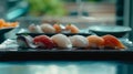 An exquisite selection of sushi nigiri, delicately crafted with the freshest fish, presented on a sleek, dark slate board