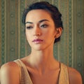 Exquisite style. a beautiful and elegant young woman posing in a green wallpapered room.