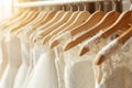 Exquisite white bridal gowns hanging in upscale boutique, close up view for bridal dress shopping