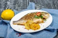 Exquisite white grilled fish with lemon in restaurant