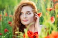 Exquisite young woman smiling in a poppy field. Beautiful make-up. The concept of health, nature, cosmetics and care