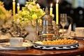 Served dinner table decorated with lit candles in beautiful candlesticks and a vase of flowers