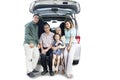 Extended Asian family sitting in the car trunk