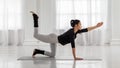 Extended Cat Cow Pose. Beautiful young asian woman practicing yoga pose on gray mat at yoga studio.