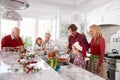 Extended Family Group Preparing Christmas Meal In Kitchen Royalty Free Stock Photo