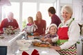 Extended Family Group Preparing Christmas Meal In Kitchen