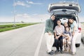 Extended happy family sitting on the car trunk Royalty Free Stock Photo