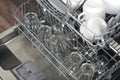On the extended shelves of the dishwasher, clean mugs and glasses, close-up