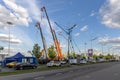 Extended telescopic booms of mobile cranes and telescopic lifting cradles at an open exhibition area of the Bauma CCT