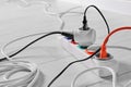 Extension cord with electrical plugs on white laminated floor, closeup