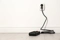 Extension cord with power plug in socket indoors, space for text. Royalty Free Stock Photo