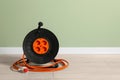 Extension cord reel on floor near light green wall, space for text. Electrician\'s equipment Royalty Free Stock Photo