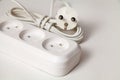 Extension cord for three sockets with a coiled cord on a white background