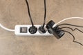 Extension power outlet socket overloaded with plugs, USB adapter with charge cables plugged into power strip Royalty Free Stock Photo
