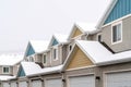 Exterior of apartments with gable roofs and dormers covered with snow in winter