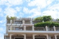 Exterior of beautiful building with balconies decorated with green plants against blue sky, low angle view Royalty Free Stock Photo