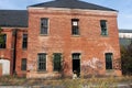 Exterior of boarded up and abandoned brick asylum hospital building with broken windows Royalty Free Stock Photo