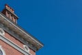 Exterior brick building with large chimney, round windows, and carved corbels, blue sky copy space