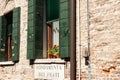 exterior brick wall with windows and sign underneath in Italian