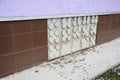 Exterior building tile foundation wall with damaged outdoor slipped, broken, missing tiles because of bad adhesive or mortar