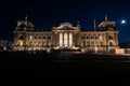 Exterior of the Bundestag with multiple flags of Germany in Berlin at night