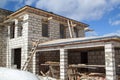 exterior of a country house under construction with scaffolding and holders for gutters water drainage system of roof. Site on Royalty Free Stock Photo