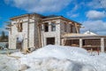 exterior of country house under construction with scaffolding and holders for gutters water drainage system of roof. Site on which Royalty Free Stock Photo