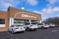 The exterior of a CVS Pharmacy with its sign logo with cars parked in the parking lot seen on a sunny day with a blue sky and Royalty Free Stock Photo