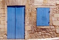 Exterior detail of a traditional stone house with closed blue window and door. Royalty Free Stock Photo