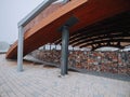 Exterior details of a city concert hall made from wood, stone and metal material. Nobody. Mist in the background. Modern design Royalty Free Stock Photo