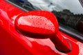 Exterior details of a luxury car. Red car side mirror close-up